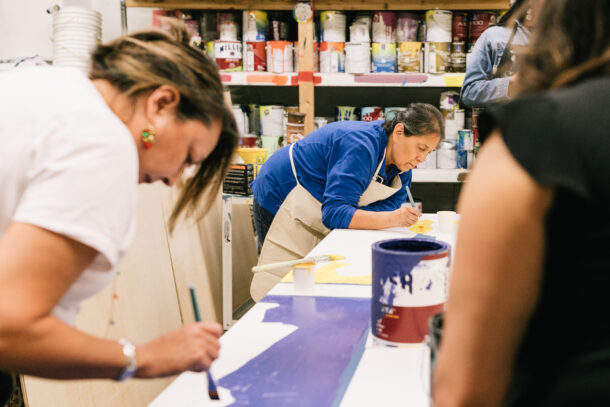 Volunteers from Native Action Network and Artist Denise L. Emerson work on panels in the Urban ArtWorks studio.