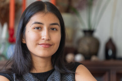 Grace woman with dark hair and tan skin smiling.