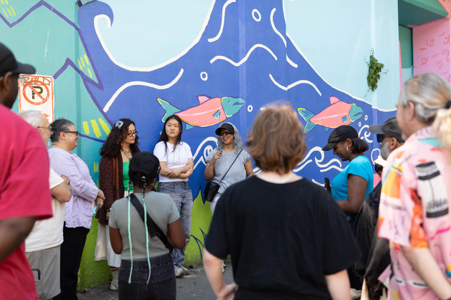 Youth artist velvet speaks to a crowd at the mural unveiling.